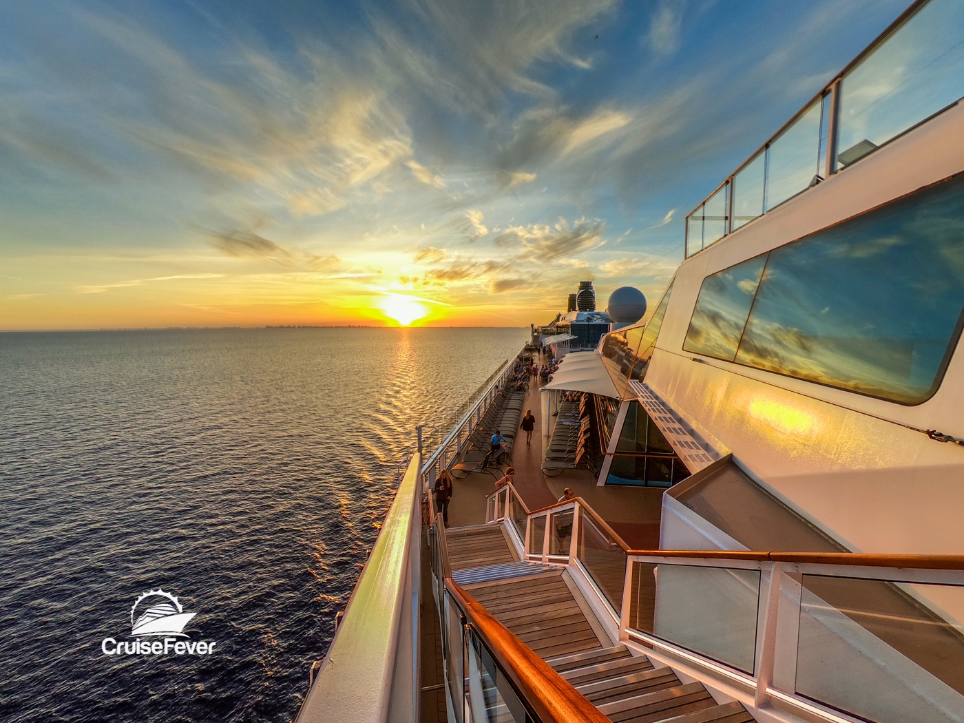 crucero de celebridades en la cubierta exterior al atardecer sobre el agua