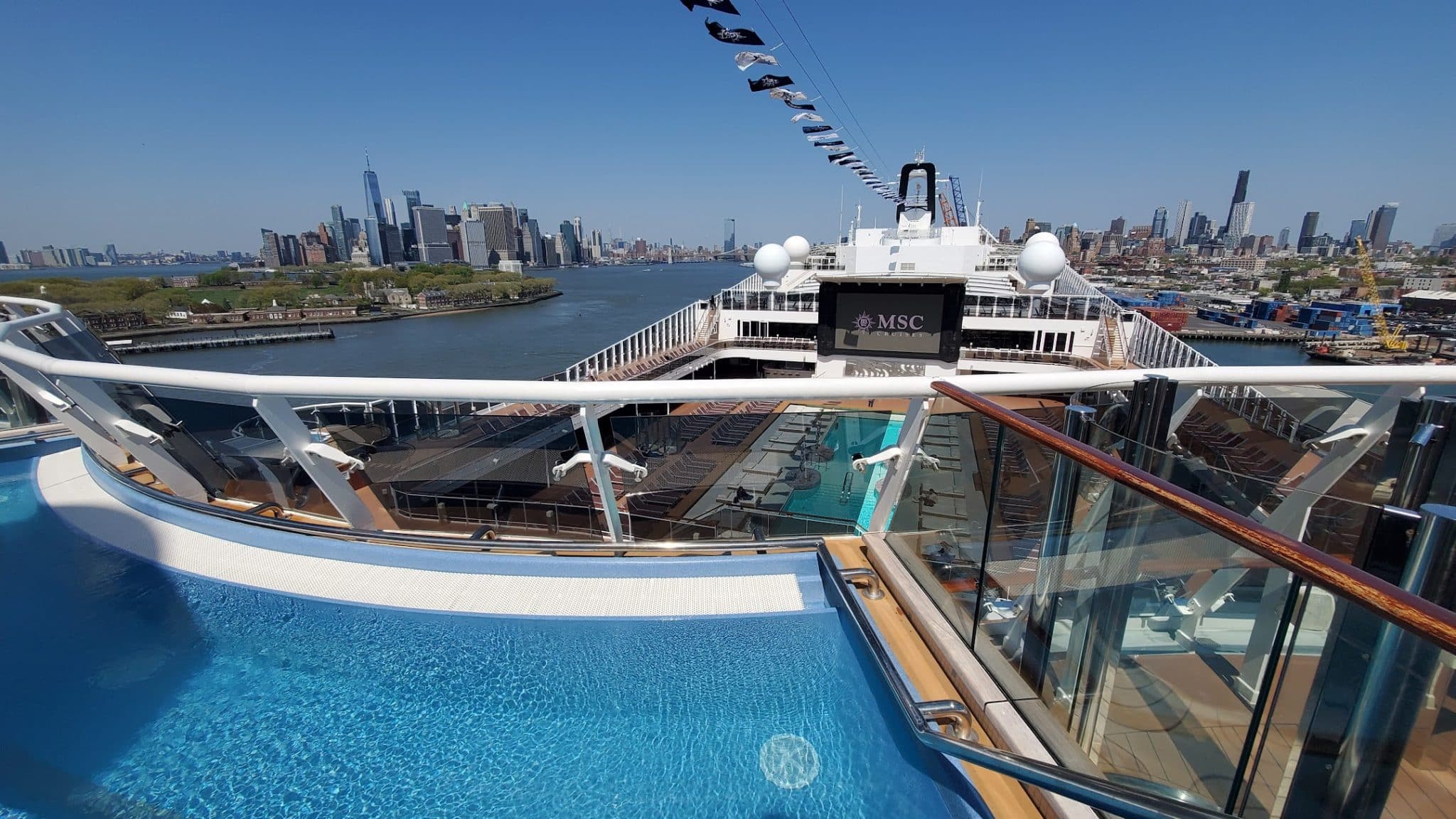 6 razones para tomar un crucero desde la ciudad de Nueva York en MSC Meraviglia Piscina superior en MSC Meraviglia que muestra la ciudad de Nueva York desde el puerto de cruceros de Brooklyn